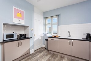 A modern kitchen with a microwave, toaster, and a window with a view.