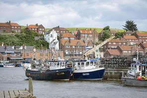 A harbor with boats docked, surrounded by residential buildings.