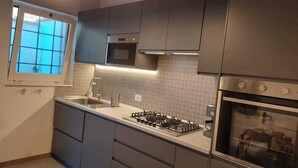 A modern kitchen with dark cabinets, a stainless steel range, and an oven.