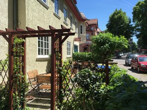 A building with a garden area, outdoor seating, and a street view. - Pension Wegerich (Erfurt)