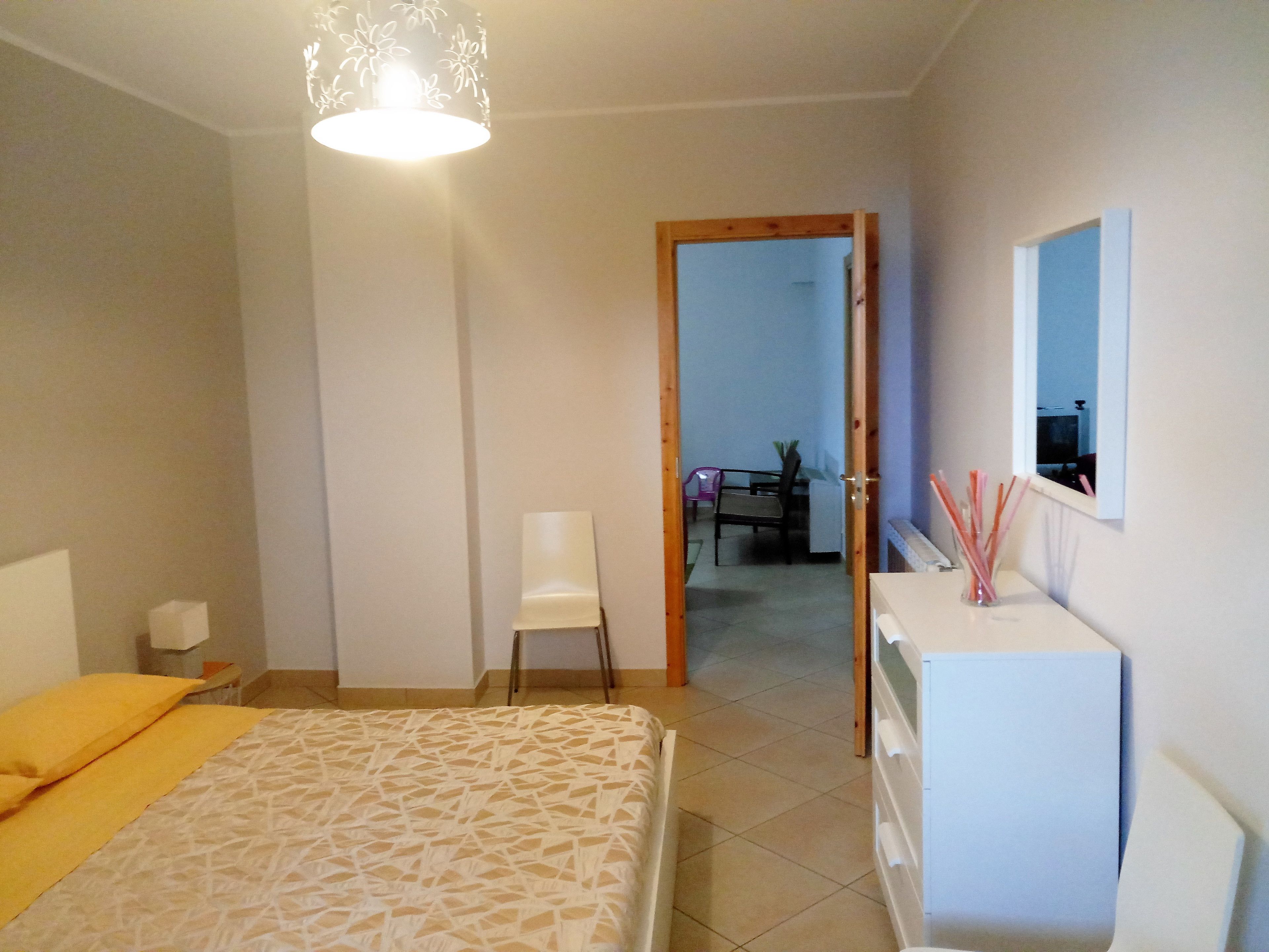 Un dormitorio con cama, escritorio, silla y cómoda.
