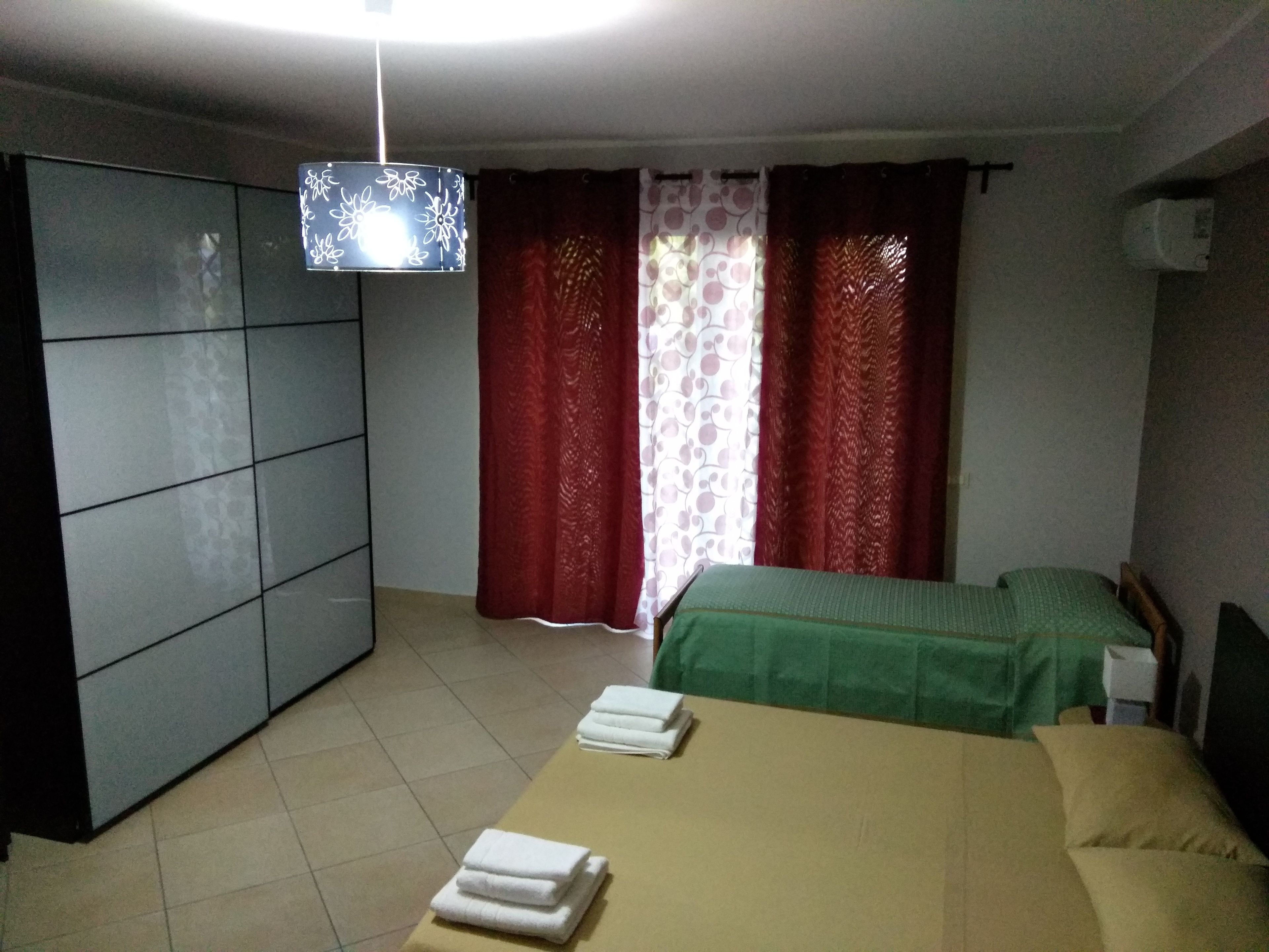 Ein Zimmer mit einem Bett, einem Kleiderschrank und einer Deckenleuchte.