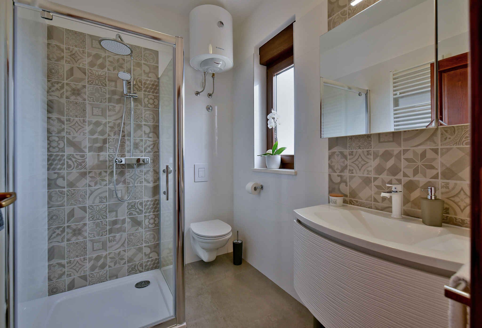 A bathroom with a shower, toilet, and sink.