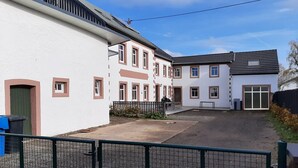 Zona residencial con un camino de entrada pavimentado que conduce a un acceso con portón.