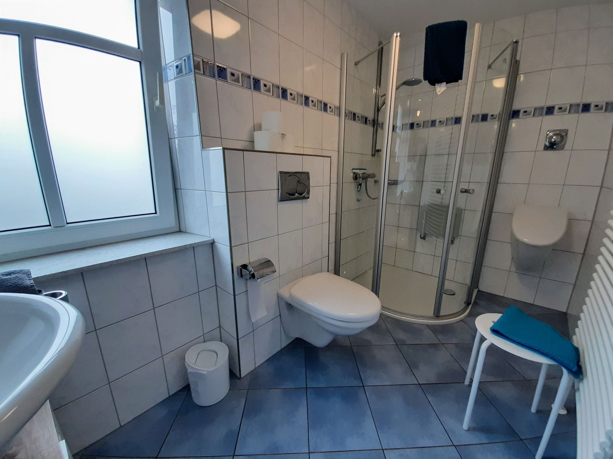 A bathroom with a toilet, sink, and glass-enclosed shower.