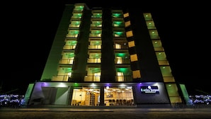 A multi-story hotel with illuminated balconies and a prominent sign for 'Exotica Sampa Hotel & Resort'. - Exotica Sampan (Cox's Bazar)