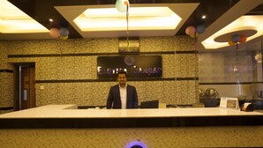 A reception desk with a clock, a sign reading "Exotica Samara," and a modern interior design. - Exotica Sampan (Cox's Bazar)