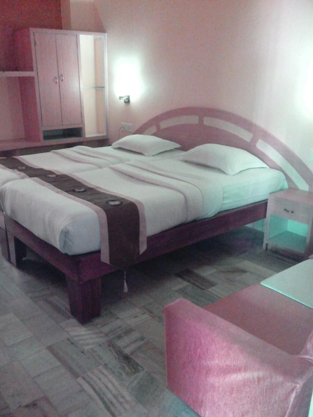 Un dormitorio con cama, mesita de noche, armario y escritorio.