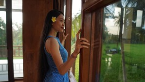 A person standing by a window with a view of a green landscape. - Nirwa Ubud Karma (Ubud)