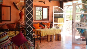 Un comedor acogedor con una mesa lista para dos, un sofá estampado y un jarrón decorativo.