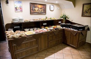 A buffet setup with various food items and a clock on the wall.