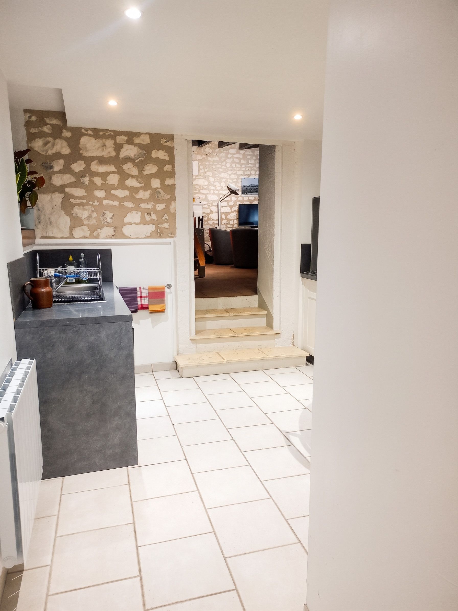 Une cuisine moderne avec un mur en pierre, un banc intégré et un sol carrelé.
