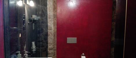 Un baño con ducha envuelta en vidrio, un lavabo blanco, un inodoro y un bidé.