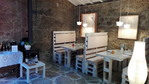 Um interior rústico com paredes de pedra, mobiliário de madeira e luminárias pendentes.