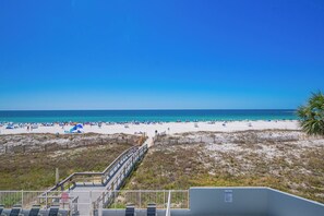 A beach with a wooden boardwalk leading to the water, sandy beach, and clear blue sky. - LIGHTHOUSE! One Bedroom XTRA BATH! Low Floor Beach Front (Gulf Shores)