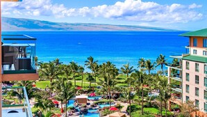 A resort with a pool area, palm trees, and a view of the ocean. - Maui Resort Rentals: Honua Kai Konea 815 - Stunning 8th Floor Ocean View Studio (Lahaina)