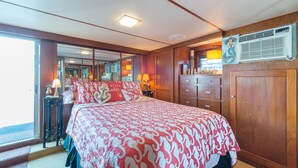 A bedroom with a large bed, wooden wardrobe, and a mirror. - NOT YOUR TYPICAL HOUSEBOAT: 60 FEET OF FUN! (Sanford)