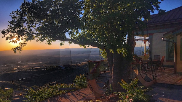 Une terrasse agrémentée d’une chaise suspendue, d’une table et de chaises, offrant une vue panoramique.