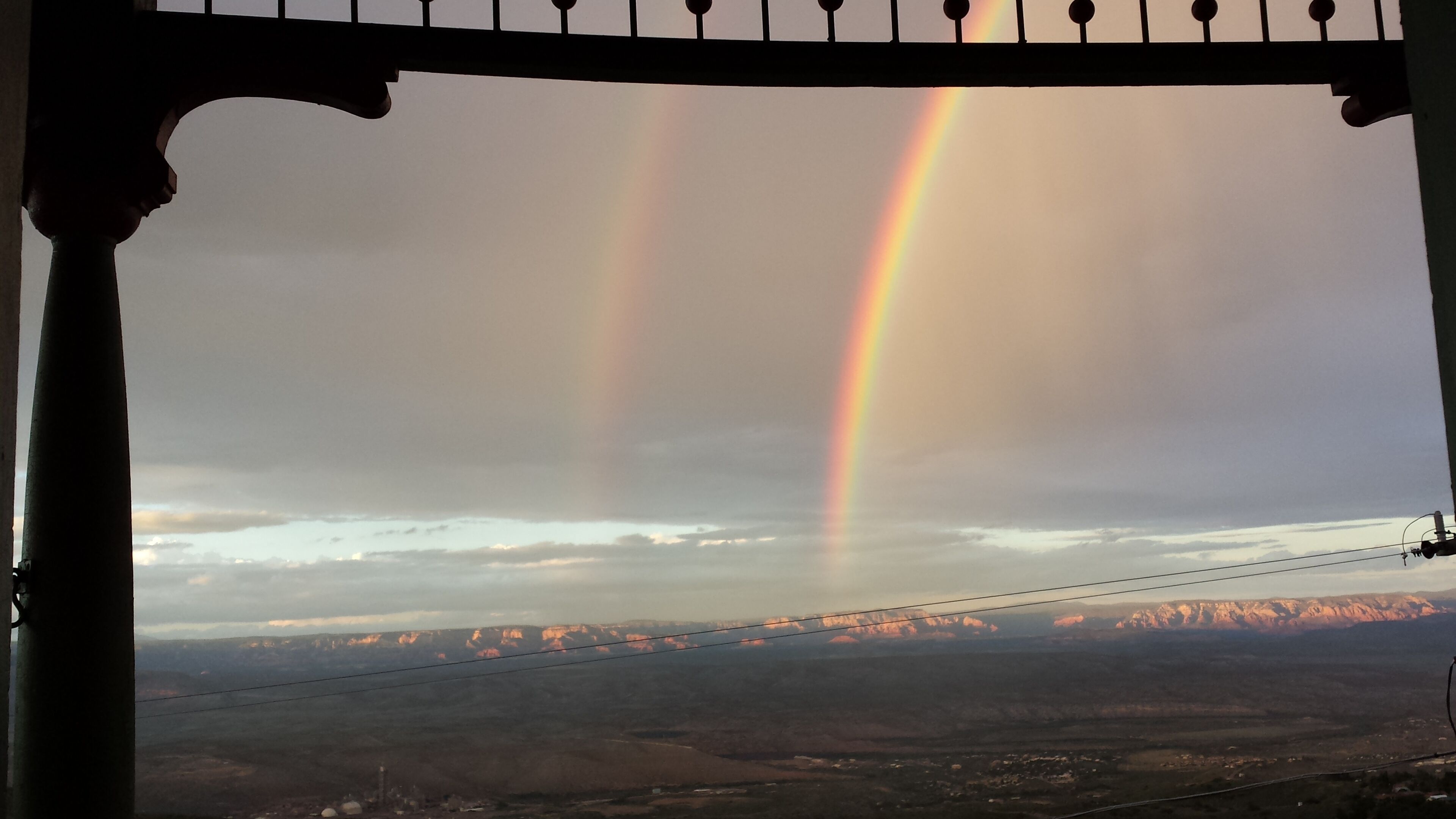 A view of a landscape with a rainbow and mountains in the distance.