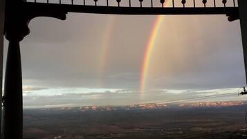 A view of a landscape with a rainbow and mountains in the distance.