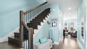 A staircase with wooden railings and a white bench with a cushion. - Splash Pad⛳️Complimentary Golf Cart & New Pool 2026 | Sleeps 13 (Miramar Beach)
