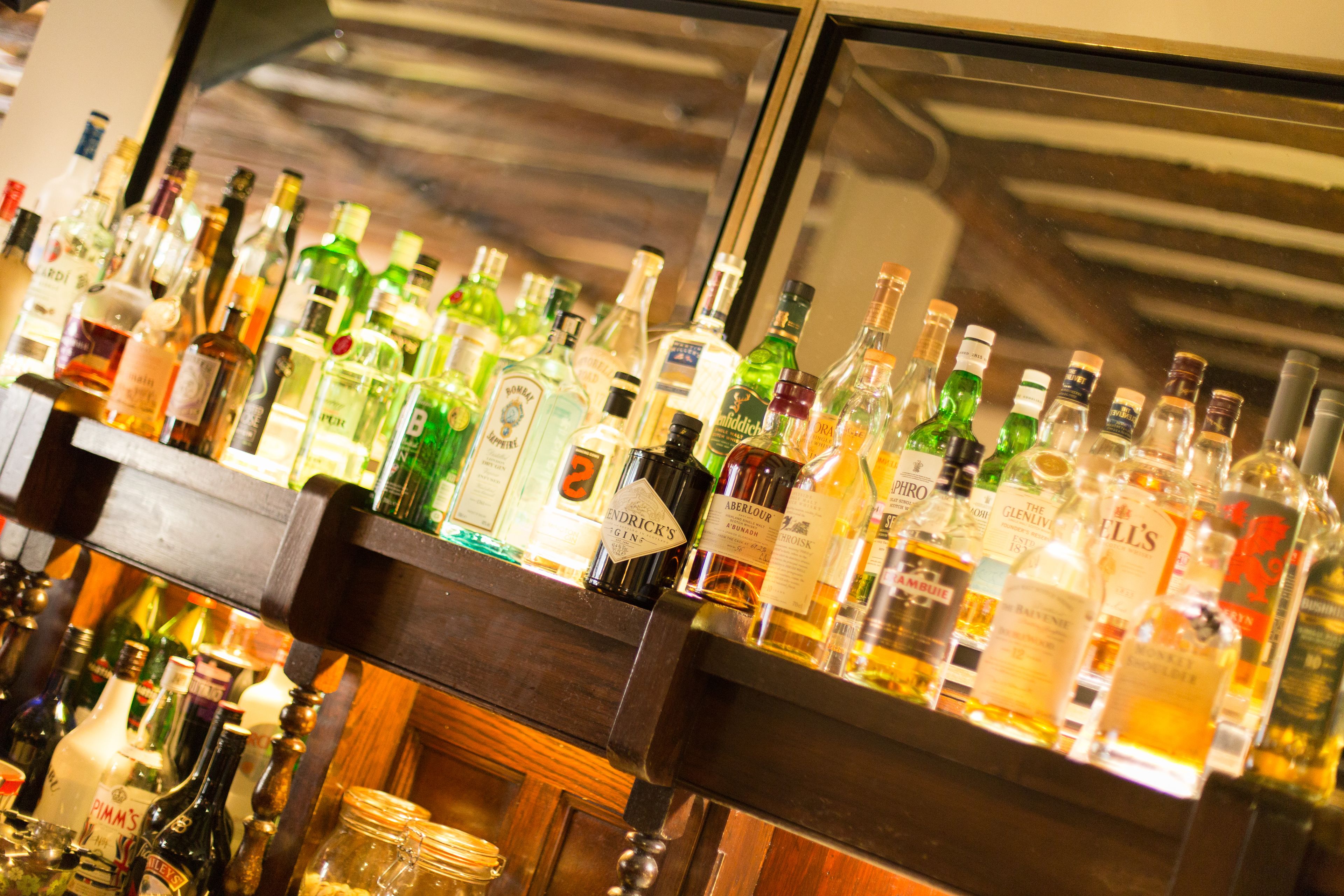 Un bar con varias botellas de licor y vasos.