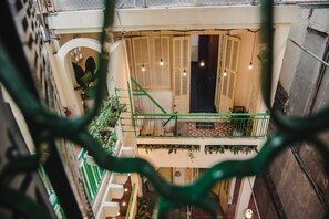 A multi-level interior with a staircase, wooden doors, and hanging lights. - Hanah's Tiny Hanoi Homestay (Hanoi)