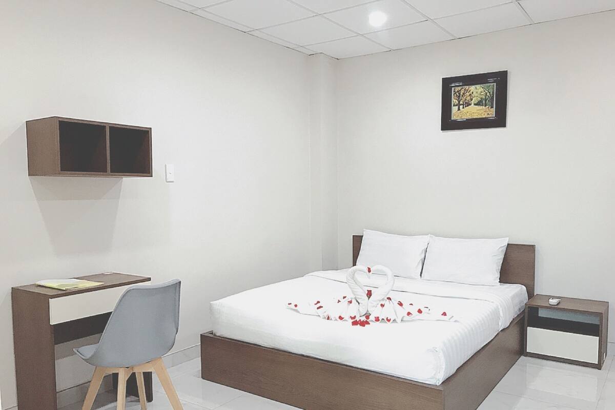 Un dormitorio con cama, escritorio y silla.