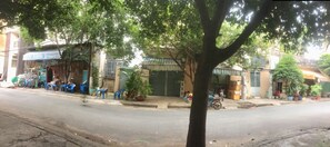 A street scene with buildings, a tree, and a parked motorcycle.