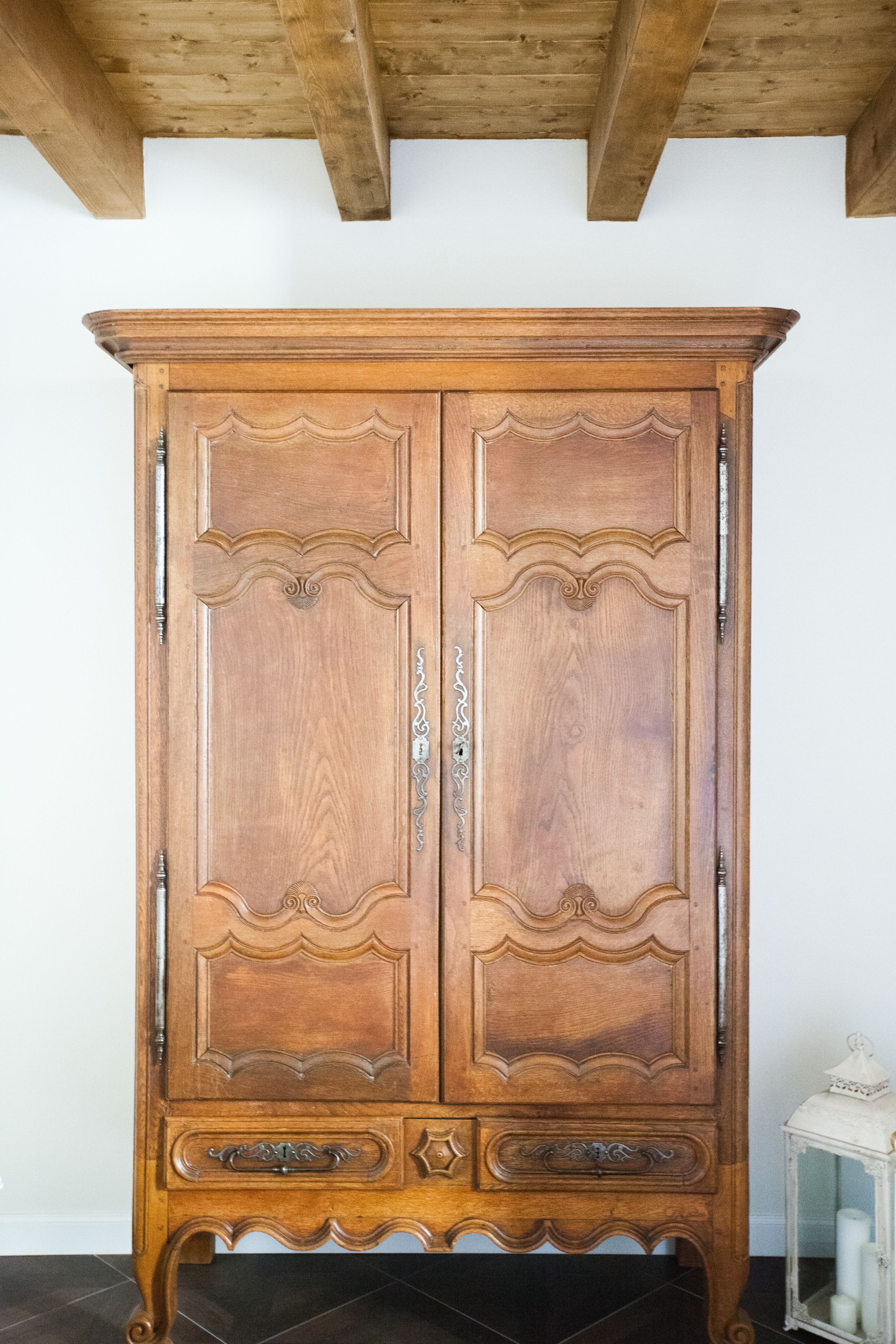 Un armadio in legno con decorazioni elaborate e una vetrina.
