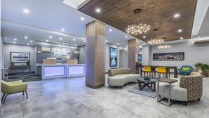 Un vestíbul modern amb una recepció, zona d'estar i un penjador.