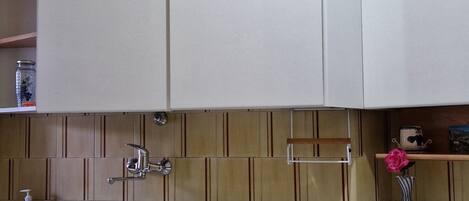A kitchen with white cabinets, a stainless steel sink, and a dishwasher.