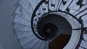 A spiral staircase with marble steps and metal railings. - City View Pescara (Pescara)