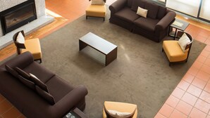 A spacious living area with a fireplace, sofas, and a coffee table. - Hotel Rural Santo António (Arronches)