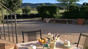 Mesa al aire libre con vistas a un paisaje rural, incluyendo campos y árboles.
