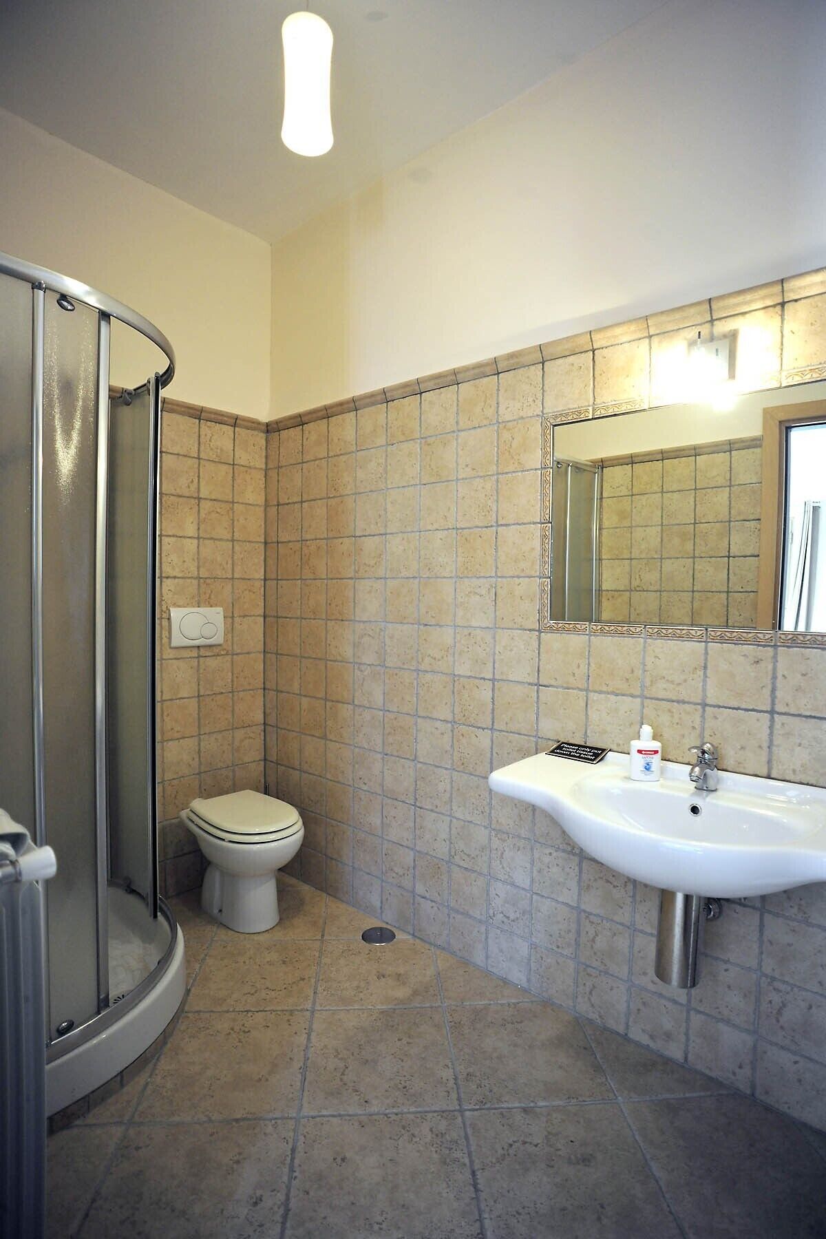 Une salle de bain avec douche, toilettes et lavabo.