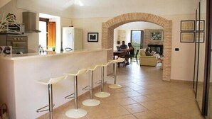 Une cuisine moderne dotée d’un bar, d’un coin repas et d’une cheminée.