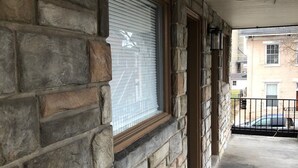 A stone exterior wall with a window and a door. - The Guest House (Circleville)
