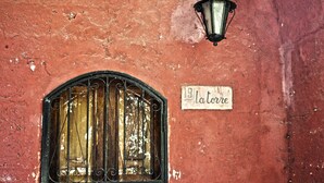 A red wall with a window featuring metal bars and a sign reading "19 la torre". - Holiday in a comfortable and renovated ancient villa (mottola)