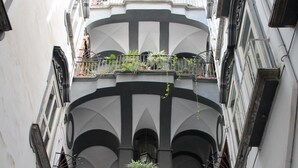 A multi-story building with balconies and arched windows. - L' Arcata a Montesanto 1700s courtyard, metro & funicular (Napoli)