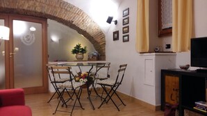 A dining area with a glass table, four chairs, and a potted plant. - L' Arcata a Montesanto 1700s courtyard, metro & funicular (Napoli)