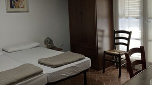A room with a bed, a wooden wardrobe, a chair, and a table. - Villetta dei lecci - Charming detached cottage (Monteverdi Marittimo)
