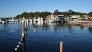 A marina with boats docked, a pier extending into the water, and buildings in the background. - Lemon Tree Passage Motel (Lemon Tree Passage)