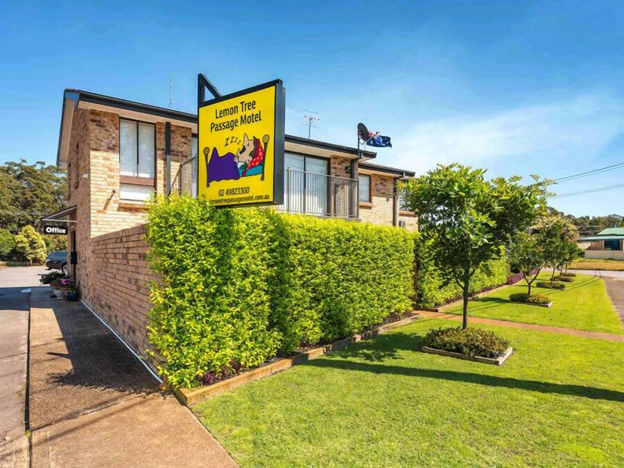 Een gebouw met een bord voor Lemon Tree Passage Motel, met een groot raam en een gevel van baksteen.