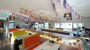 A restaurant interior with booths, a counter, and a display case. - ASURE Rotorua International Motor Inn (Rotorua)