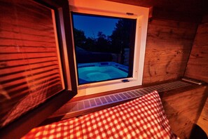 Ein Whirlpool mit Blick durch ein Fenster auf einen Garten.