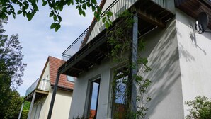 Un edificio de dos pisos con un balcón, una ventana y una puerta.