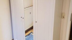 Un armario blanco con dos puertas y un espejo.