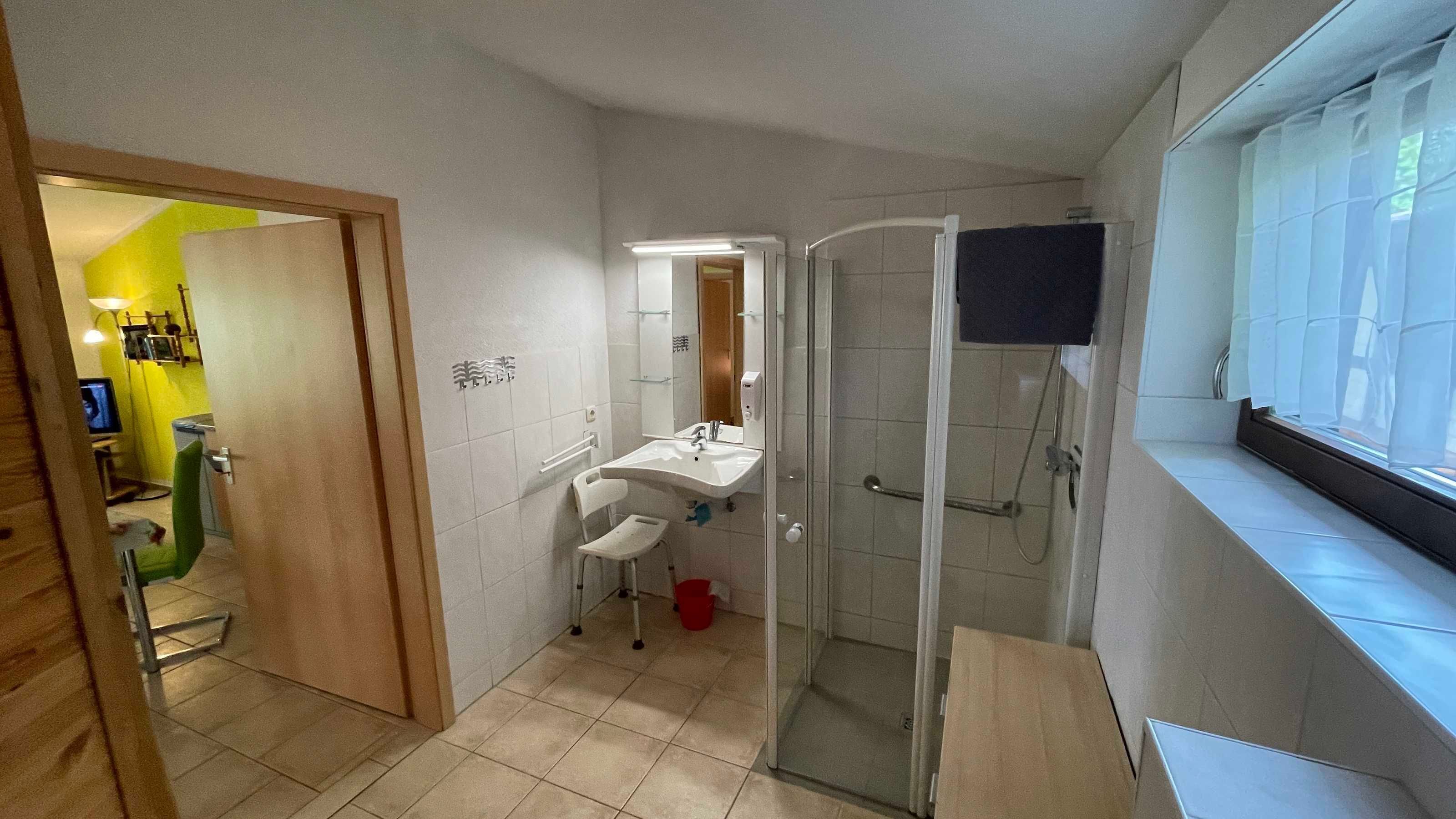 A bathroom with a sink, mirror, and glass shower enclosure.