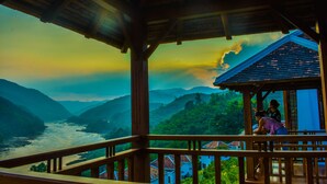 A wooden structure with a view of a river and mountains. - Le Grand Pakbeng Resort (Pakbeng)